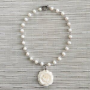 PEARL NECKLACE WITH CARVED ROSE PENDANT.